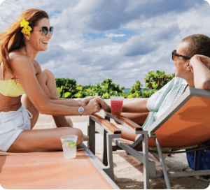 Couple in lounge chairs enjoying drinks on the private beach.
